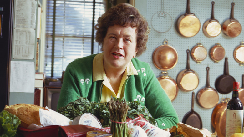 Julia Child wears a green sweater in her home kitchen