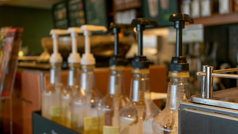 Syrup pumps lined up on the Starbucks condiment bar.