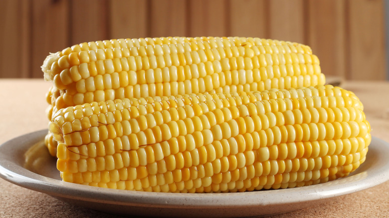 Freshly cooked corn served whole on the cob.