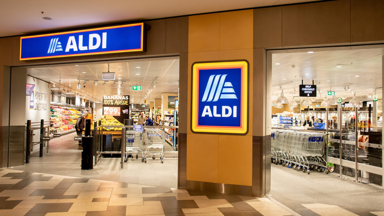 Aldi supermarket entrance with blue, illuminated signs on the walls
