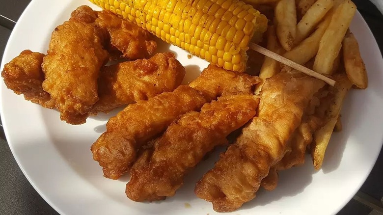 Chili's Original Chicken Crispers on plate with corn on the cob and fries