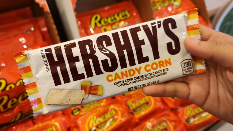 Hand holds a Hershey's candy corn chocolate bar