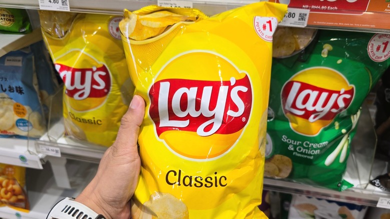 A bag of Lay's potato chips being held up to the camera.