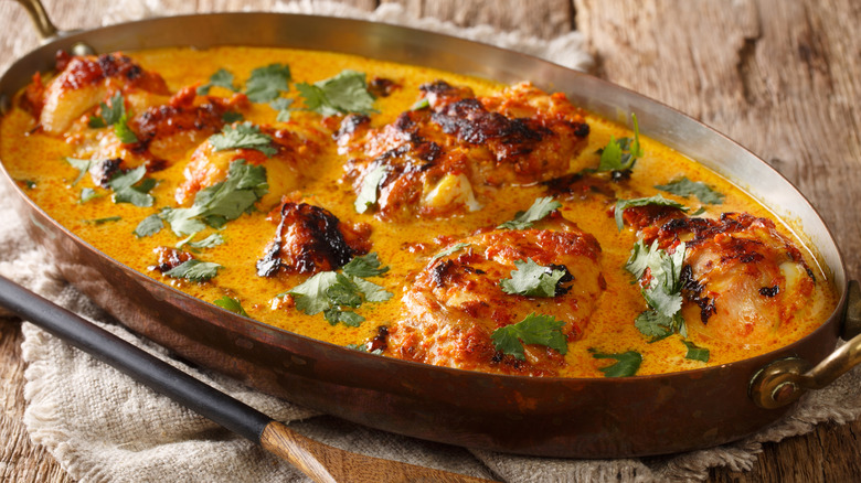 Pan of East African kuku paka with grilled chicken