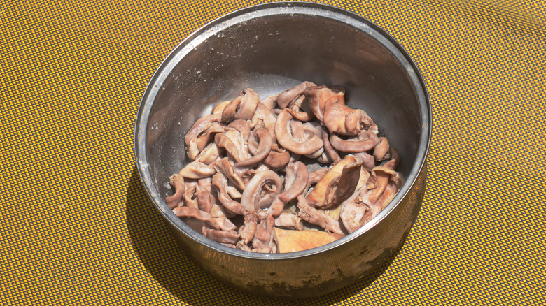 Close-up of a metal bowl of chitlins being prepared