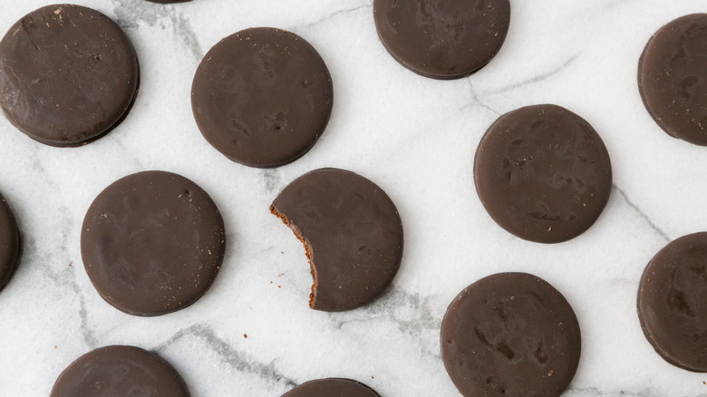 Thin Mint cookies on marble countertop with one bitten.