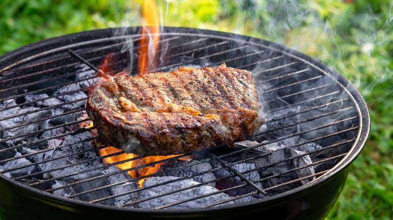 Steak being cooked on a charcoal grill