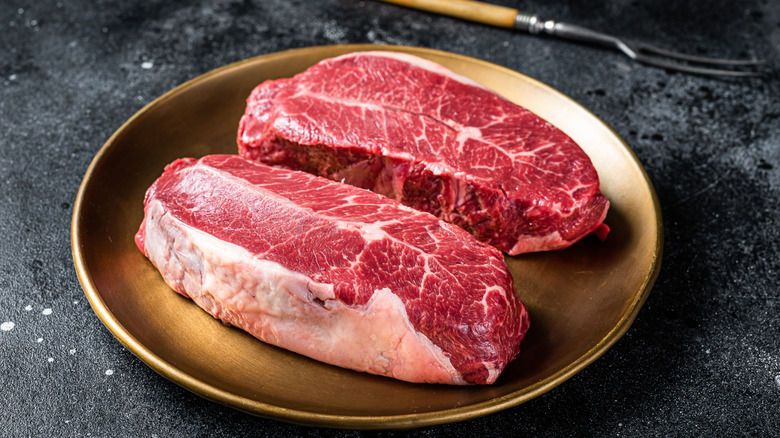 A fork next to a plate of raw meat