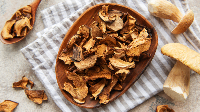 Top view of dried porcini mushrooms on wooden plate
