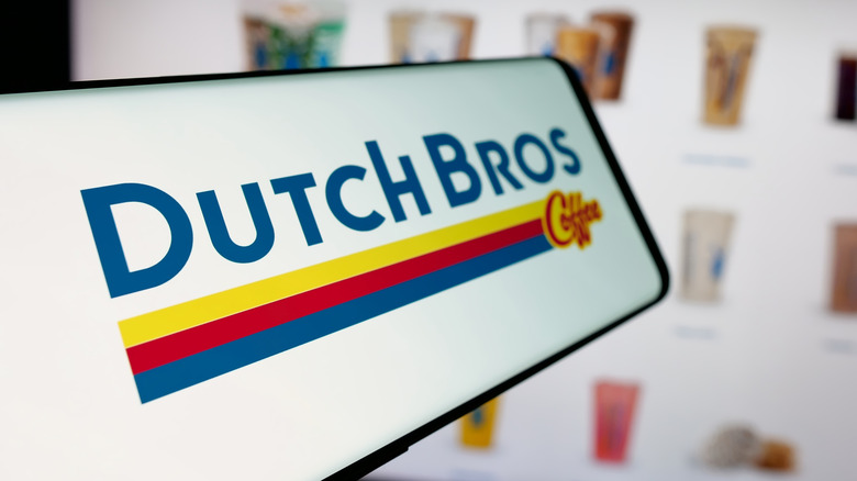 The Dutch Bros logo on a smartphone in front of the Dutch Bros menu