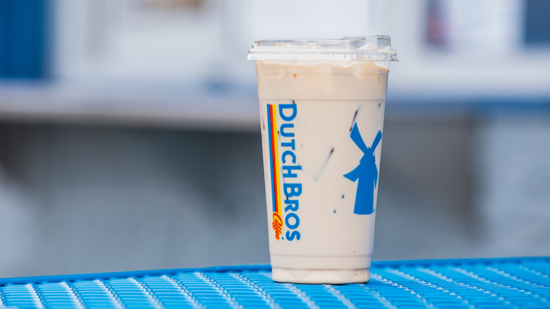 An iced drink from Dutch Bros on a blue bench