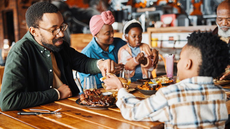 Black family eating dinner together in a restaurant