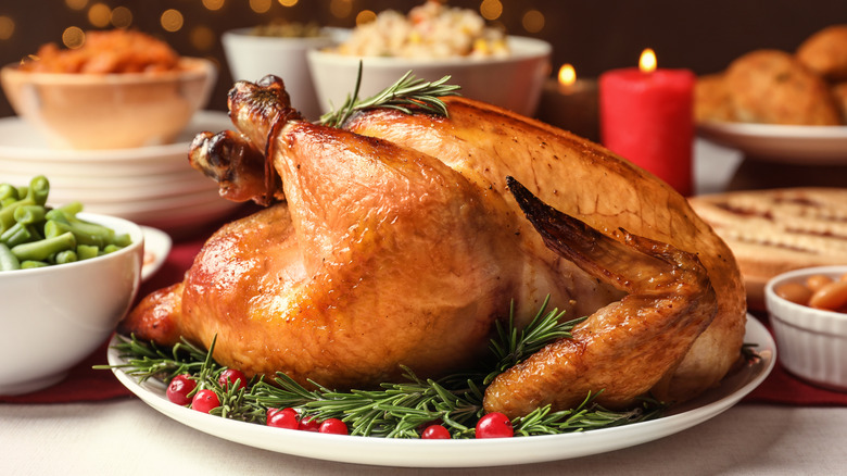A golden roasted turkey waits to be carved on a holiday dinner table
