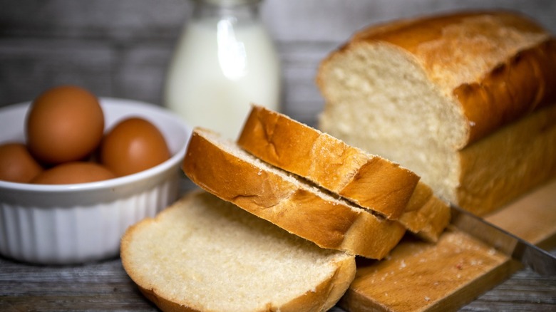 Sliced loaf of fresh bread with eggs and milk
