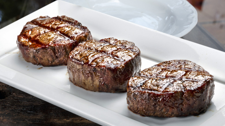 Beef tenderloin medallions on a white ceramic plate