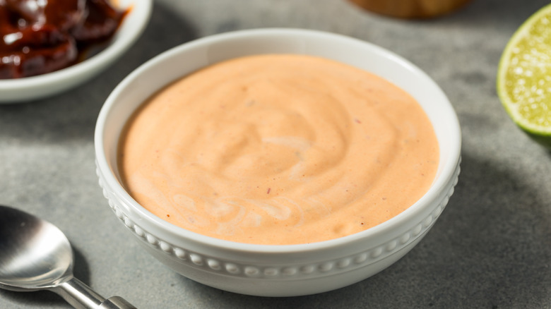 A bowl of spicy mayonnaise and a spoon