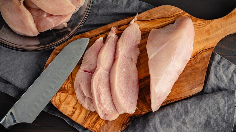 sliced raw chicken breast with a knife