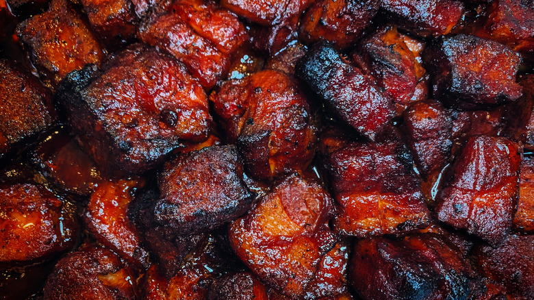 Pork burnt ends with dark char and red sauce