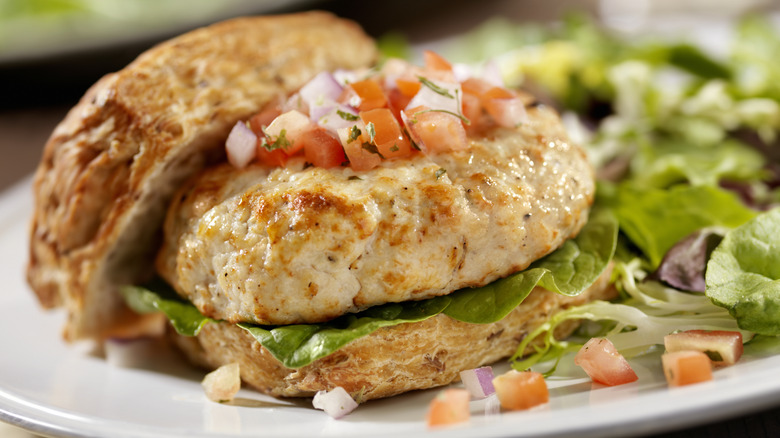 A cooked turkey burger topped with salsa