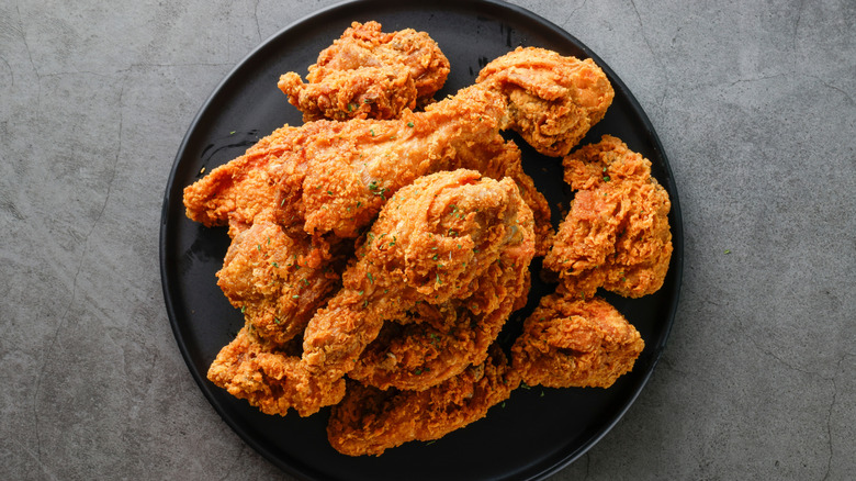 Top view of crispy fried chicken on black plate