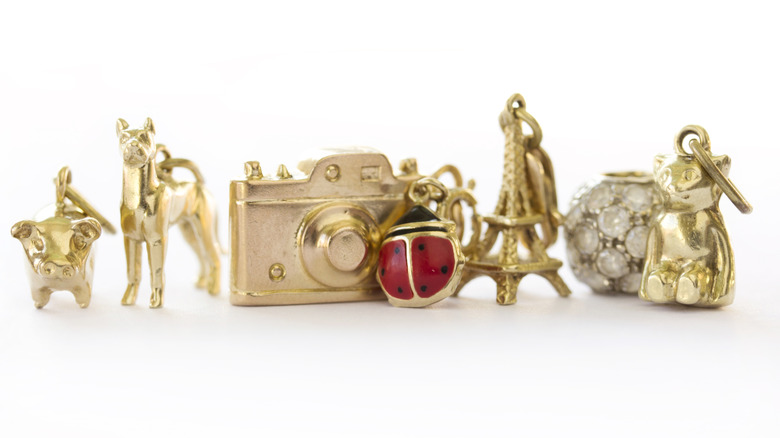A selection of gold charms including a camera, dog, and lady bug