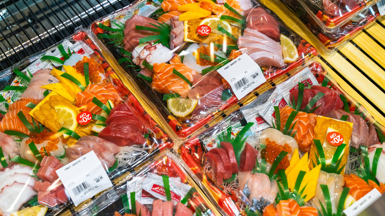 A closeup of pre-made containers of sashimi on a store shelf in Osaka Marketplace in Fremont, California
