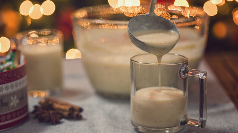 Ladling eggnog into a clear glass