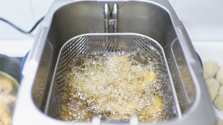 A deep fryer with food cooking inside.