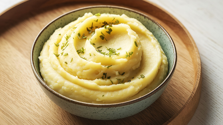 Mashed potatoes with dried herbs in a ceramic bowl