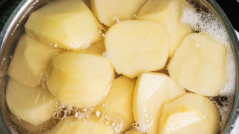 Chopped and peeled potatoes being boiled in a pan