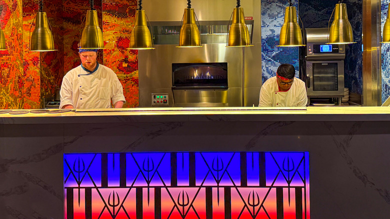 Two chefs working in the red and blue kitchens in a Hell's Kitchen restaurant