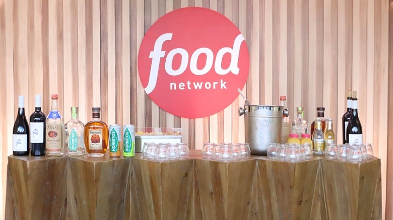 A drinks table at a Food Network event with the network's logo above it.