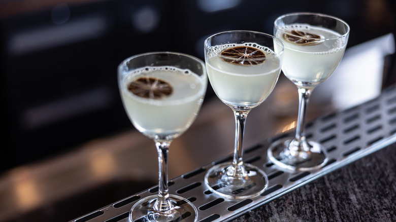 Three gimlets lined up at a bar