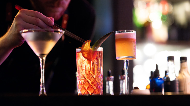 A bartender carefully crafting cocktails