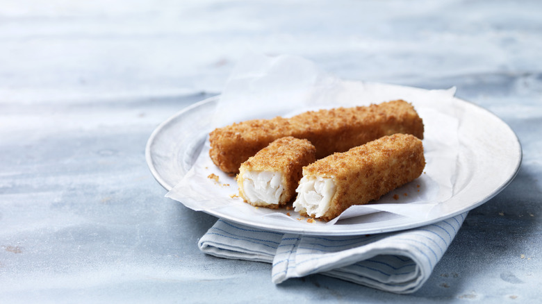 a plate of fish sticks on a light blue background