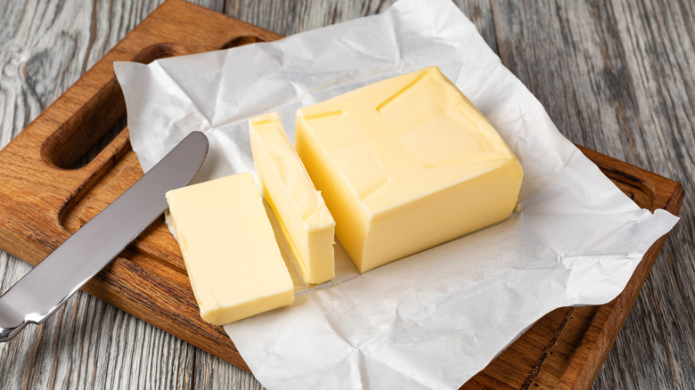 A block of butter sitting on a wooden board