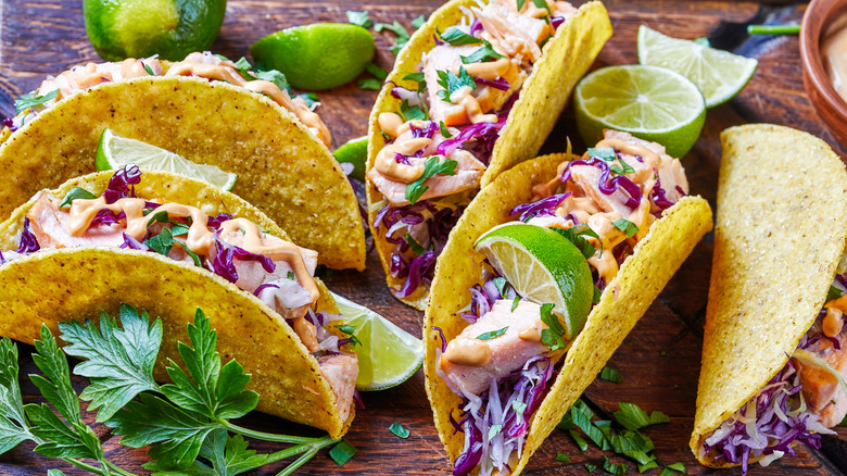 A platter of salmon tacos with cilantro, lime, and cabbage slaw