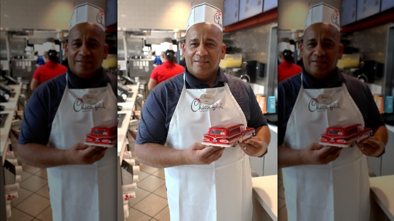 Chick-fil-A store manager holding a model car