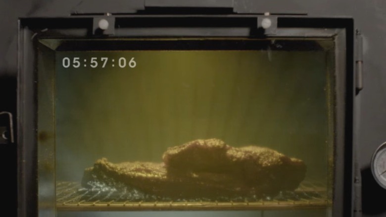 A screenshot from the famous 13-hour Arby's commercial featuring a brisket smoking behind a glass door.