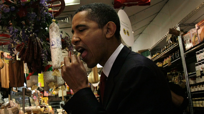 President Barack Obama eating a piece of cheese at a market