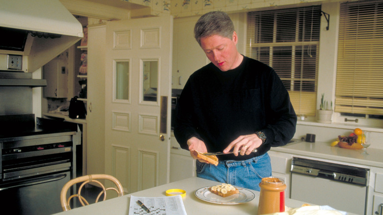Bill Clinton making a peanut and banana sandwich in a kitchen