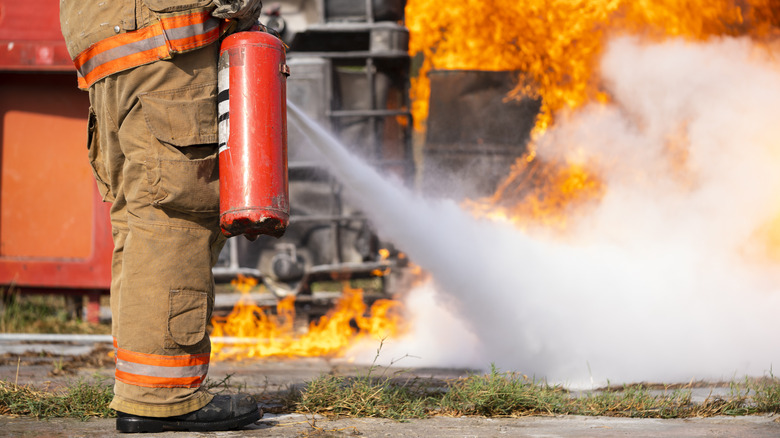 A fireman demonstrates proper use of a fire extinguisher