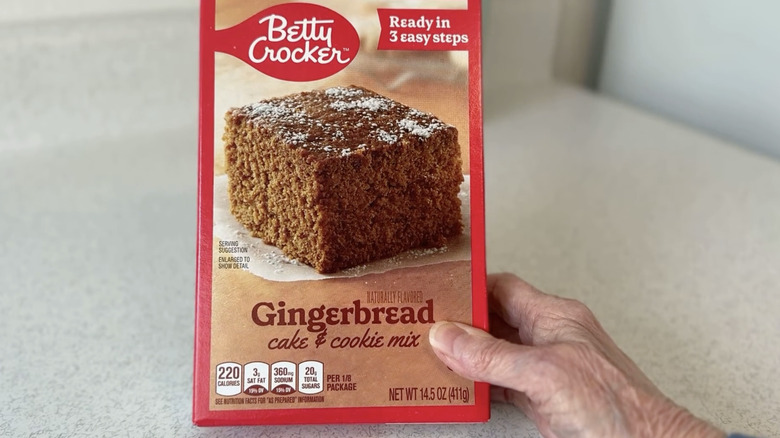 A hand holding a box of the Betty Crocker gingerbread cake and cookie mix