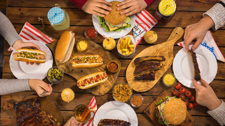 Top view of people eating hot dogs, ribs, and burgers