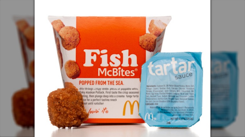 Orange and white Fish McBites carton with one golden fried McBite and a blue and white tartar sauce mini-cup