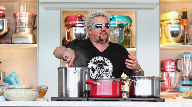 Guy Fieri prepares food at the Whole Foods Market Grand Tasting Village Featuring MasterCard Grand Tasting Tents & KitchenAid® Culinary Demonstrations during the 2015 Food Network & Cooking Channel South Beach Wine & Food Festival at Grand Tasting Village on February 21, 2015 in Miami Beach, Florida.