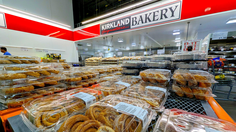 Kirkland Signature bakery at Costco sign with cinnamon rolls in boxes in the foreground.