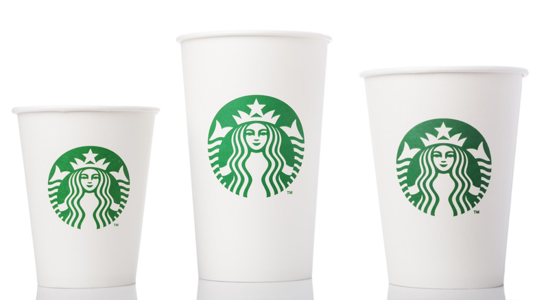 Three different sized Starbucks cups on white