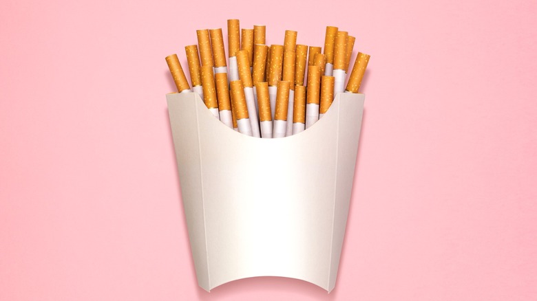 Cigarettes in a french fry box on pink background