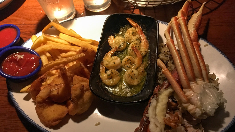 A seafood platter with shrimp, crab, fries, and sauces served at Red Lobster